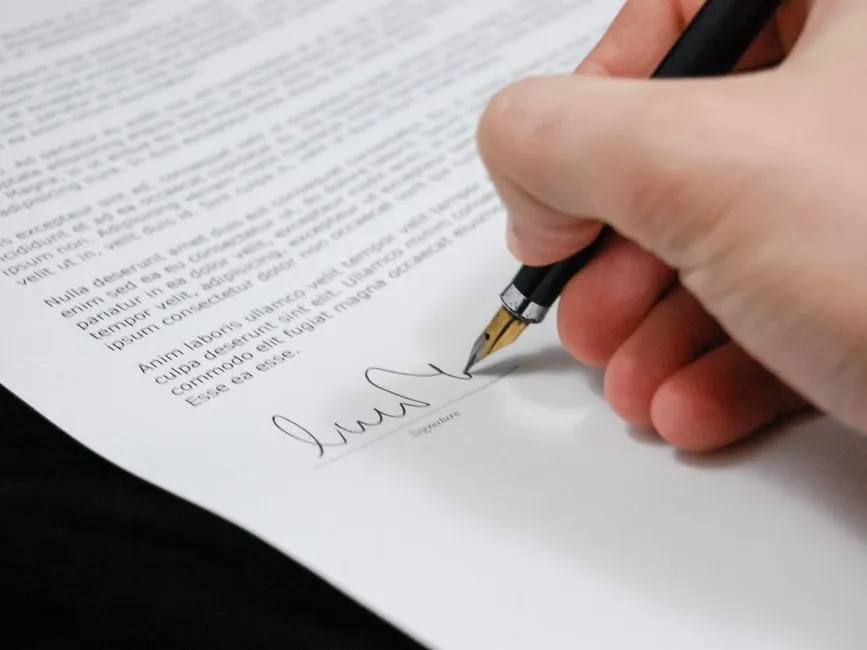Document d'attestation de témoin signé à la main posé sur un bureau avec stylo et dossier juridique