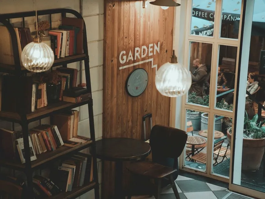 Intérieur chaleureux d'un café librairie avec étagères de livres et comptoir en bois